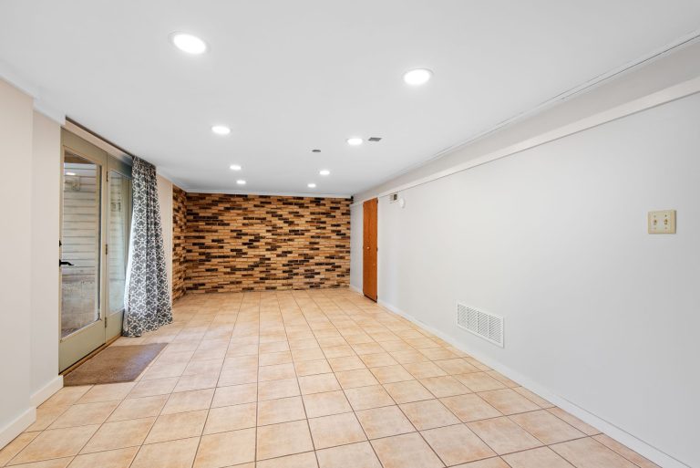 Tile flooring in an Ohio basement entry with a brick accent wall