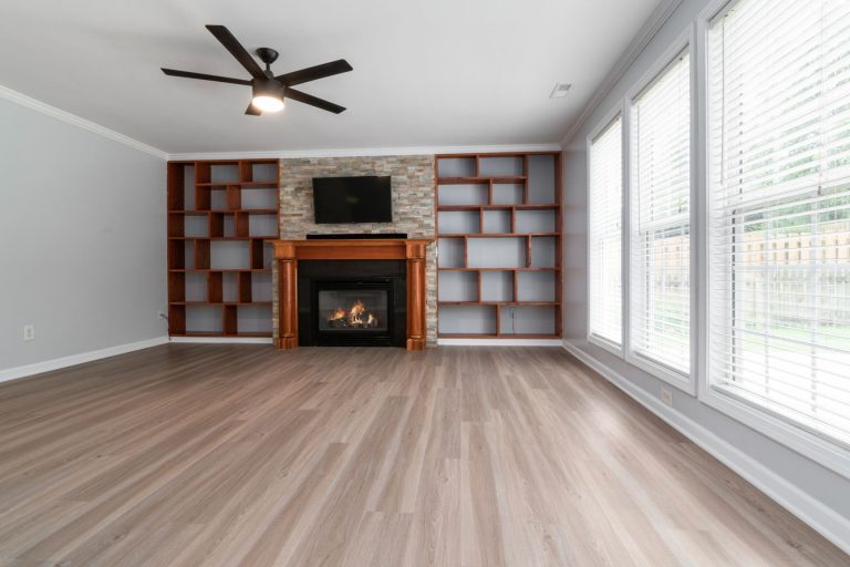 Spacious living room featuring a fireplace, built-in shelving, and large windows